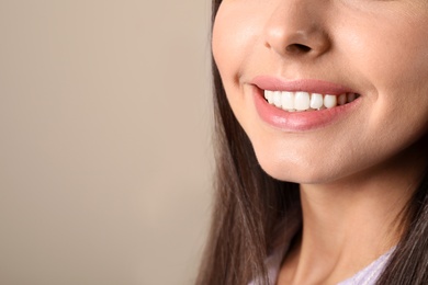 Young woman with healthy teeth on color background, closeup. Space for text