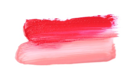 Photo of Strokes of color lip glosses isolated on white, top view