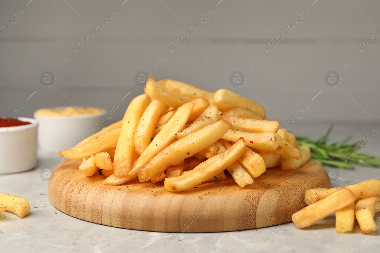 Photo of Delicious french fries on light grey marble table