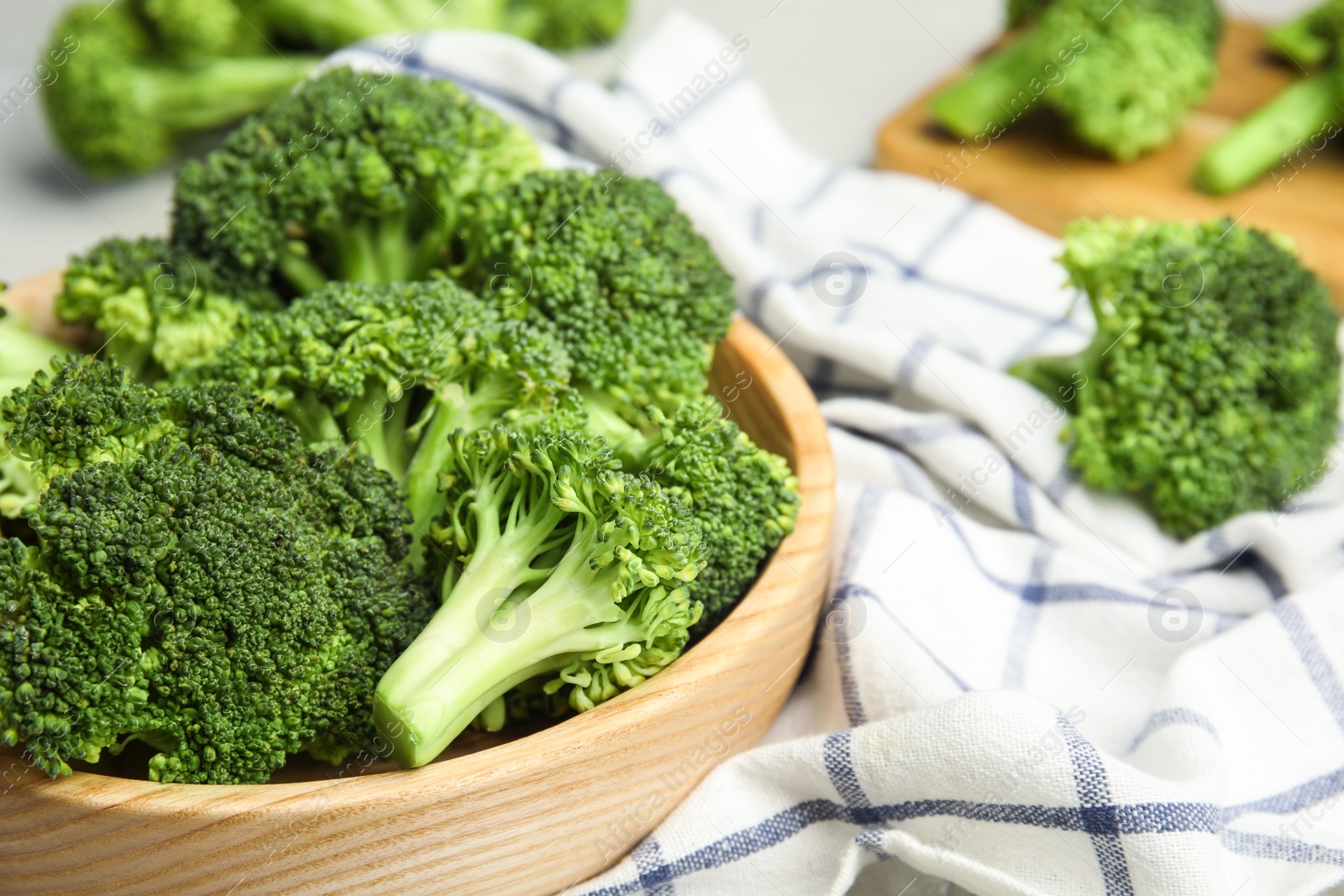 Photo of Fresh green broccoli in wooden bowl, closeup. Space for text