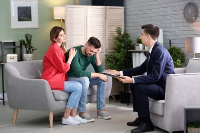 Photo of Young couple with problem at family psychologist office