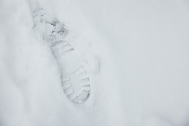 Top view of footprint on white snow outdoors, space for text. Winter weather