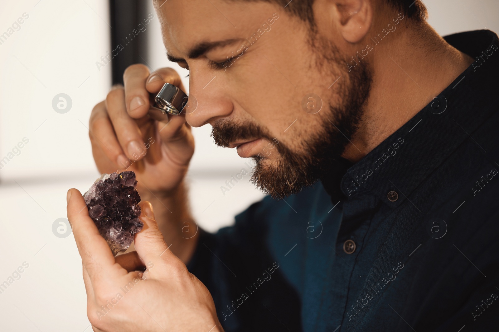 Photo of Jeweler working with gemstone on blurred background, closeup