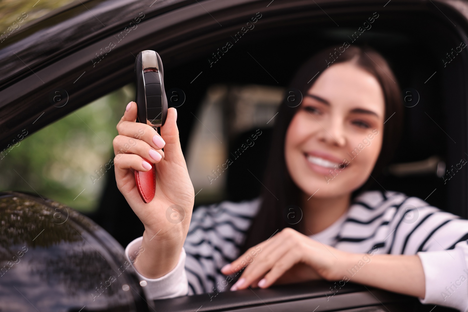 Photo of Woman holding car flip key inside her vehicle, selective focus