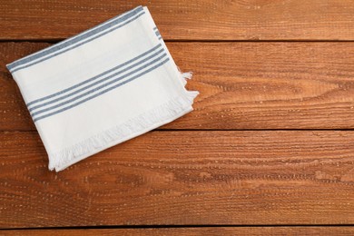 Striped kitchen towel on wooden table, top view. Space for text