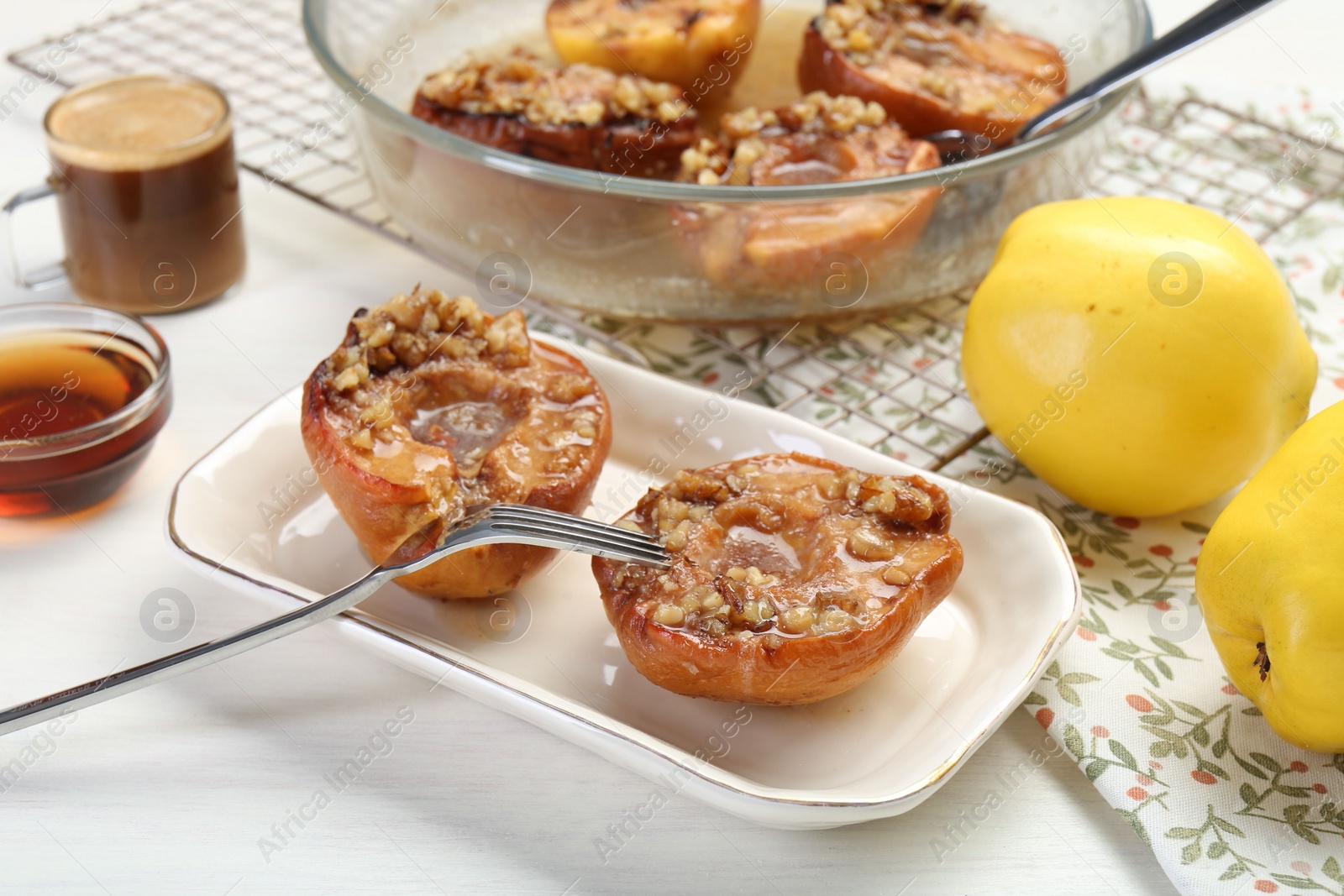 Photo of Delicious quinces baked with honey and walnuts on white wooden table