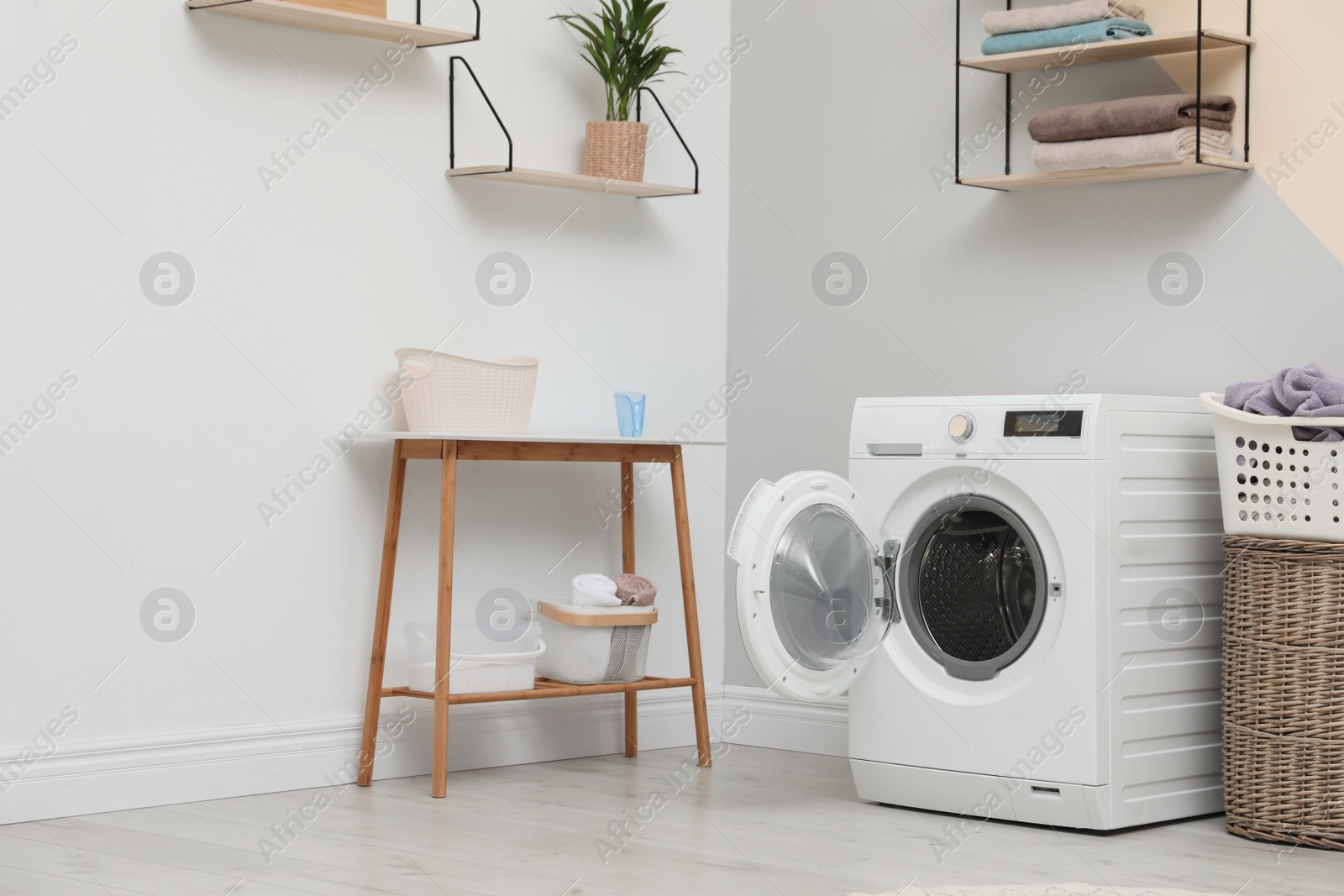 Photo of Modern washing machine in laundry room interior