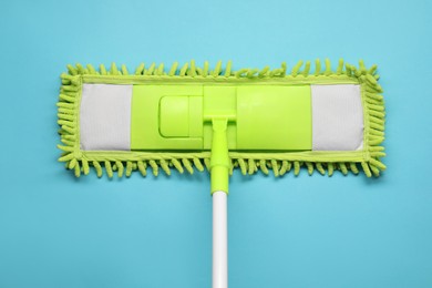 Photo of Mop with plastic handle on light blue background, top view