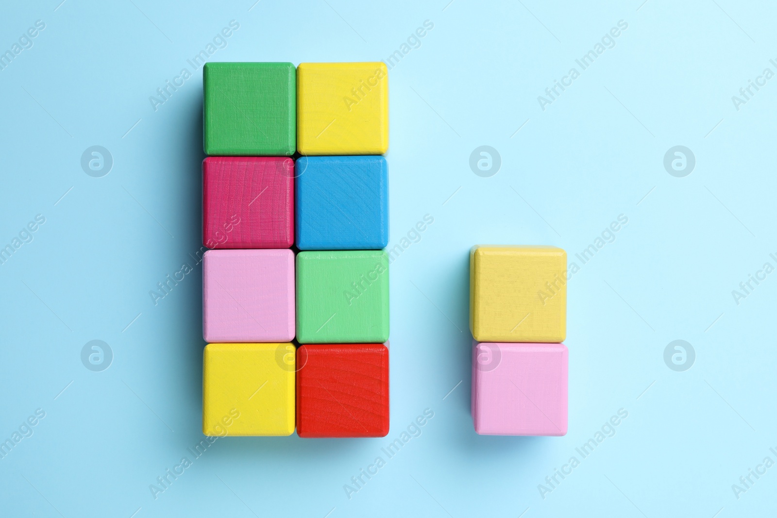 Photo of Flat lay composition with colorful cubes on light blue background. Pareto principle concept