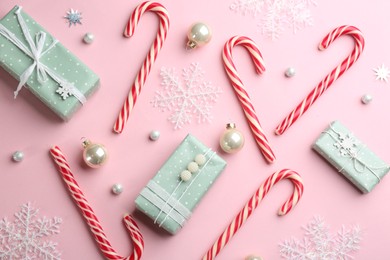Photo of Flat lay composition with candy canes and Christmas decor on pink background