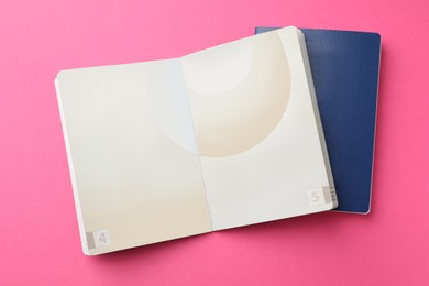 Photo of Blank passports on pink background, flat lay