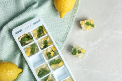 Flat lay composition with ice cube tray and and lemons on table