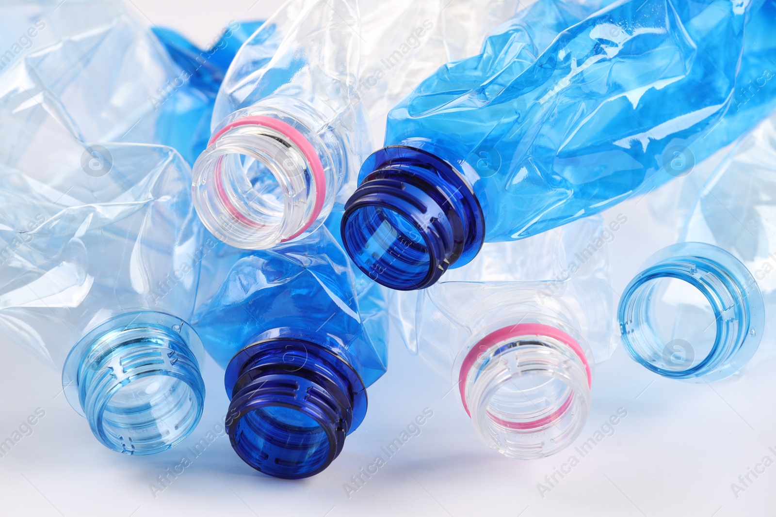 Photo of Crumpled disposable plastic bottles on white background