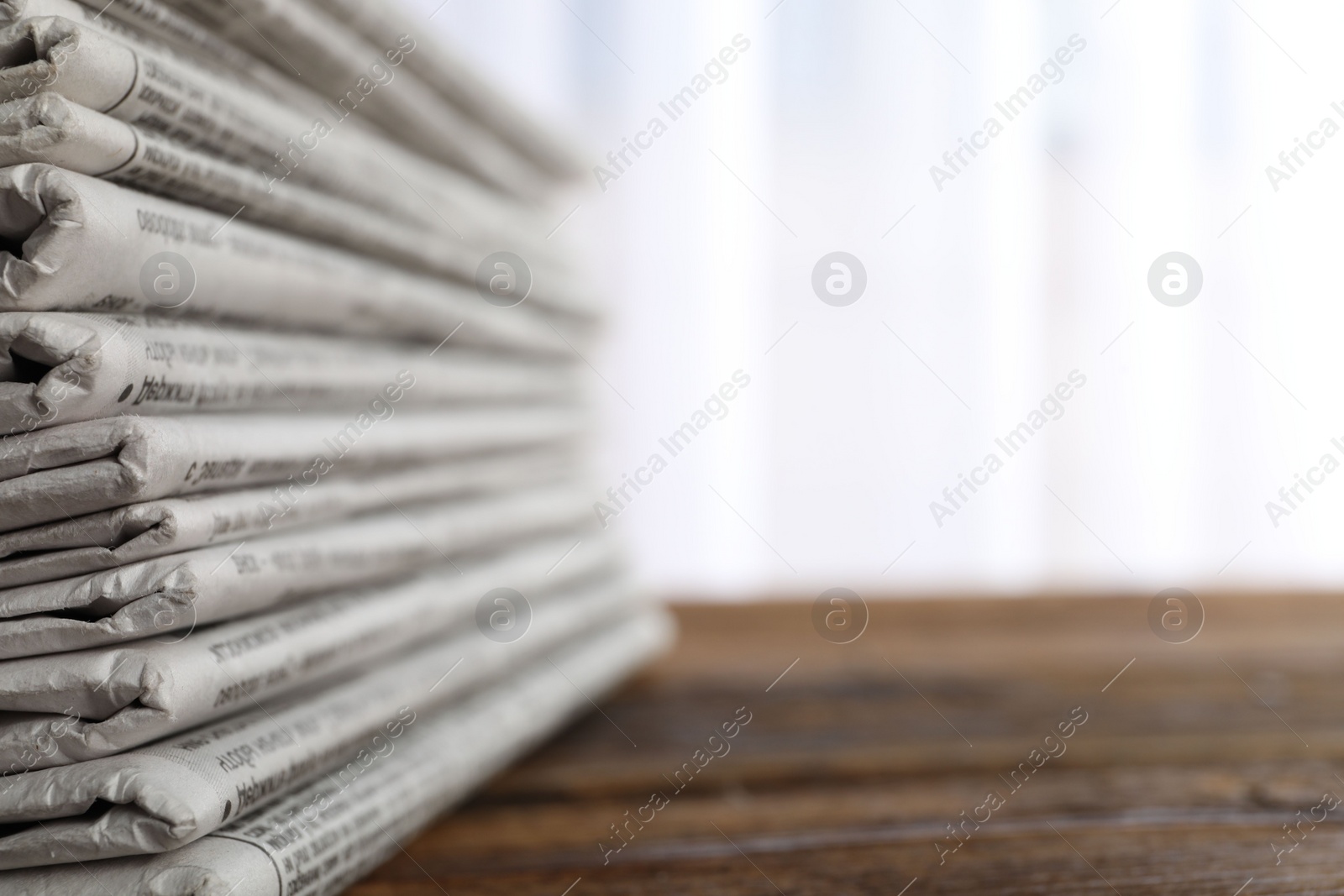 Photo of Stack of newspapers on wooden table, space for text. Journalist's work