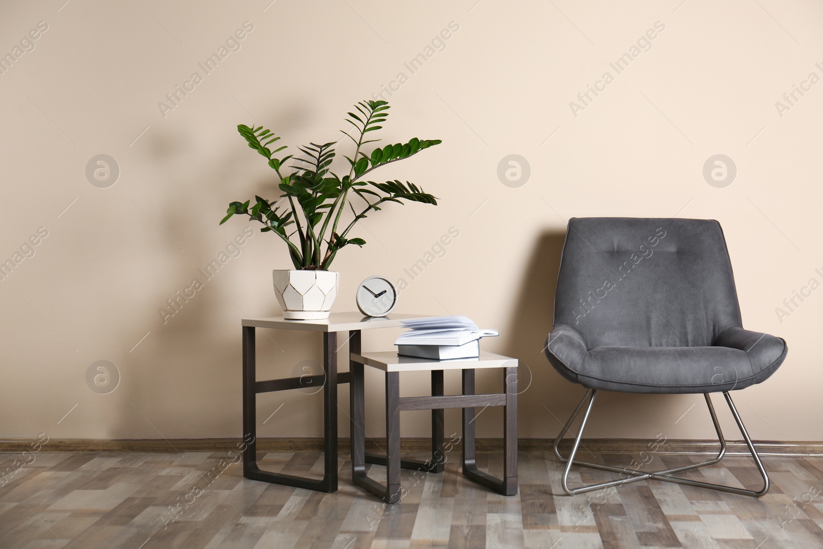 Photo of Stylish room interior with comfortable chair near color wall