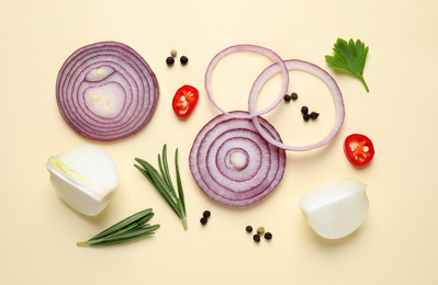 Photo of Flat lay composition with cut onion and spices on beige background