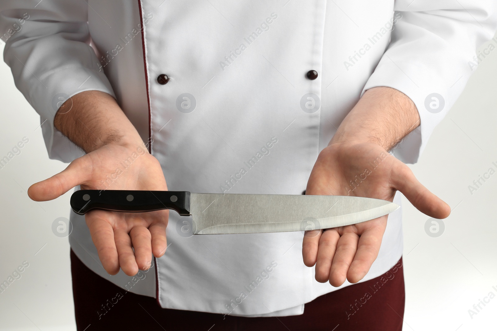 Photo of Man holding chef's knife on white background, closeup