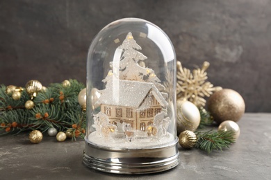 Photo of Beautiful Christmas snow globe and festive decor on grey table