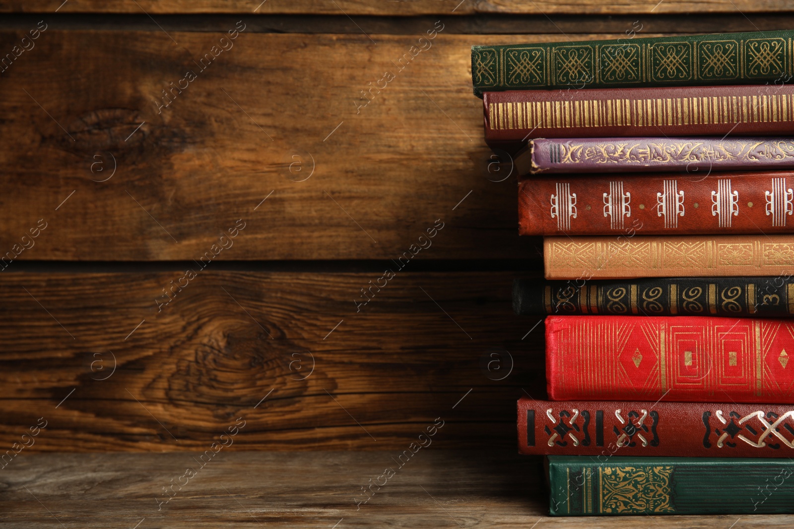 Photo of Collection of different books on table against wooden background. Space for text
