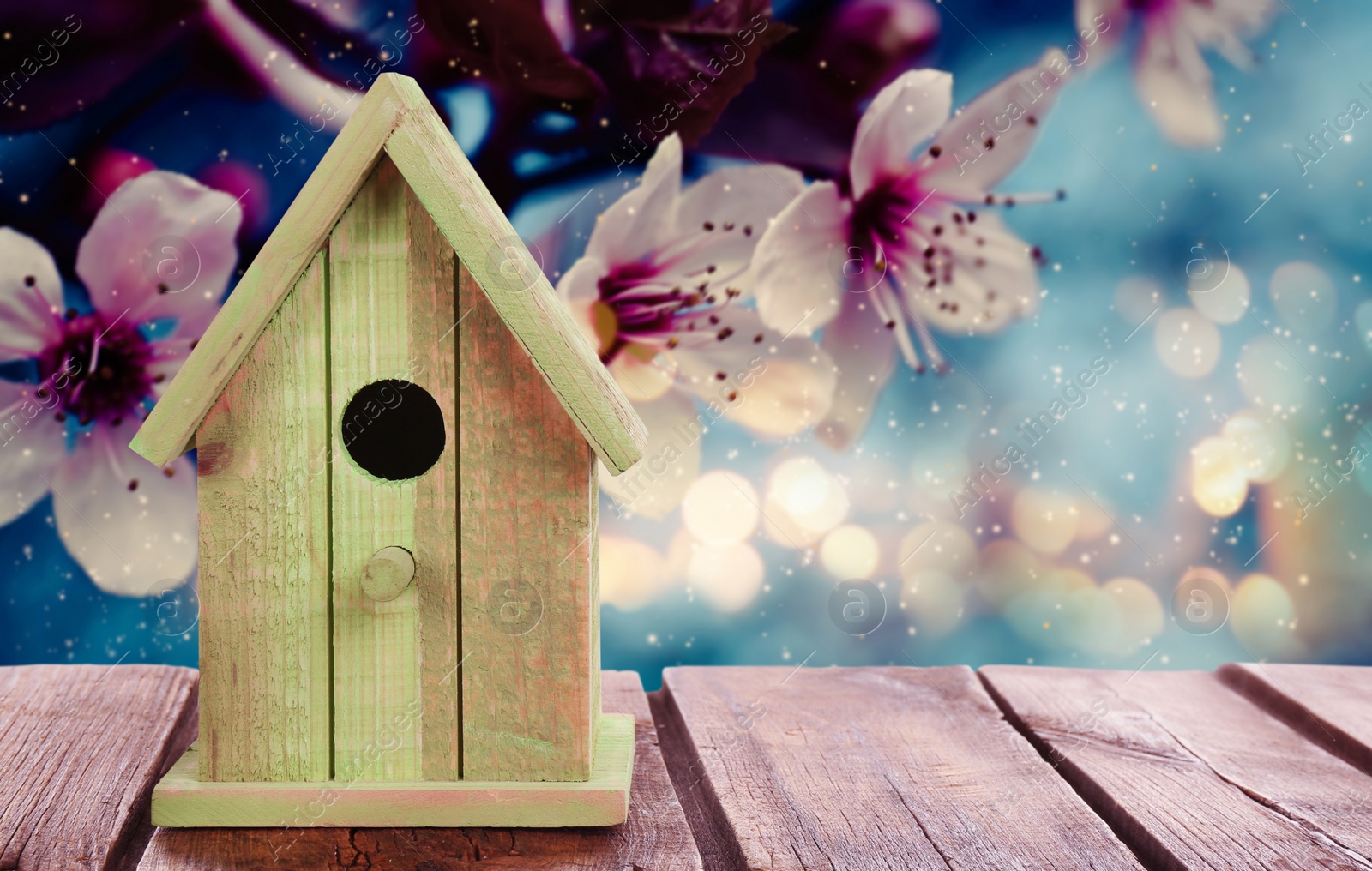 Image of Beautiful bird house on wooden table outdoors, space for text