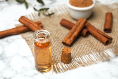 Bottle with cinnamon essential oil on table