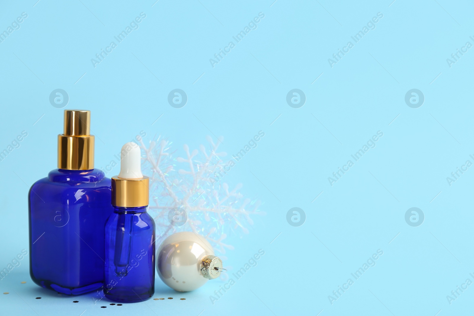 Photo of Beautiful composition with cosmetic products on light blue background, space for text. Winter care