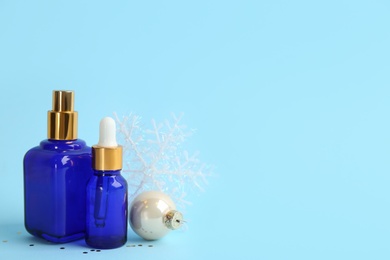 Beautiful composition with cosmetic products on light blue background, space for text. Winter care