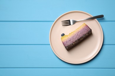 Delicious cheesecake with blueberry on light blue wooden table, top view. Space for text