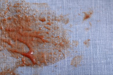 Photo of Denim shirt with stain of sauce, closeup