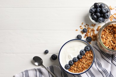 Photo of Tasty yogurt served with blueberries and muesli on white wooden table, flat lay. Space for text
