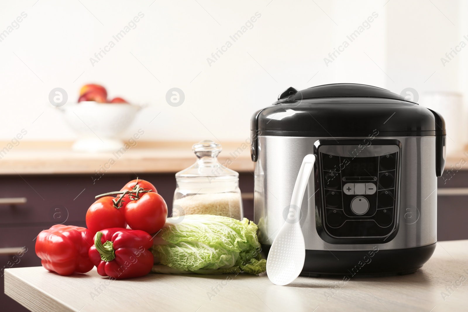 Photo of Modern multi cooker and products on table in kitchen. Space for text