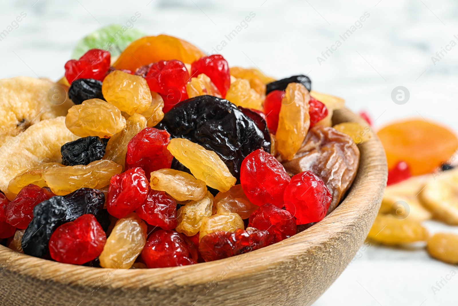 Photo of Bowl with different dried fruits on table, closeup. Healthy lifestyle