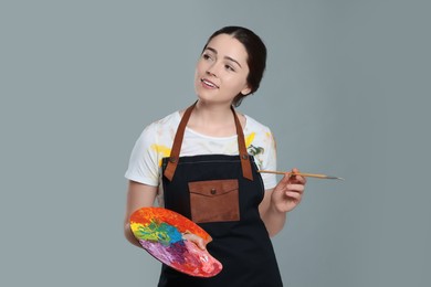 Woman with painting tools on grey background. Young artist