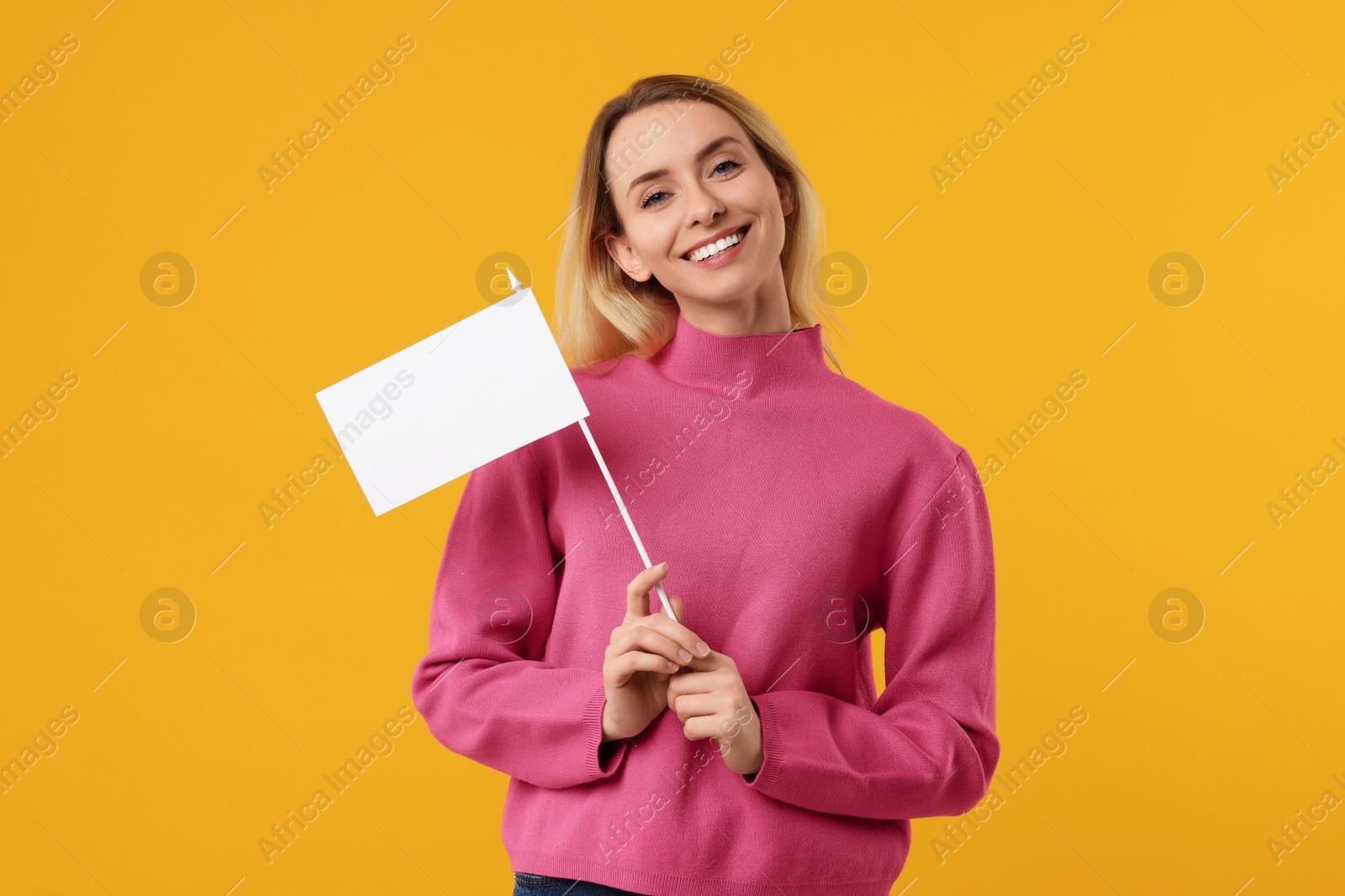 Photo of Happy woman with blank white flag on orange background. Mockup for design