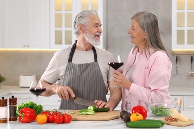 Photo of Affectionate senior couple cooking together in kitchen