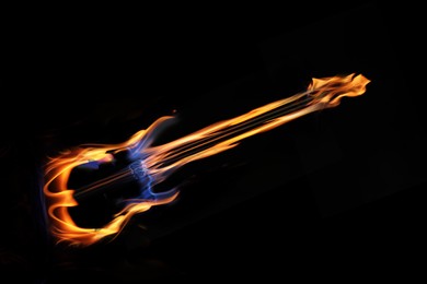 Image of Flaming electric guitar on black background, bright design, Rock music concept