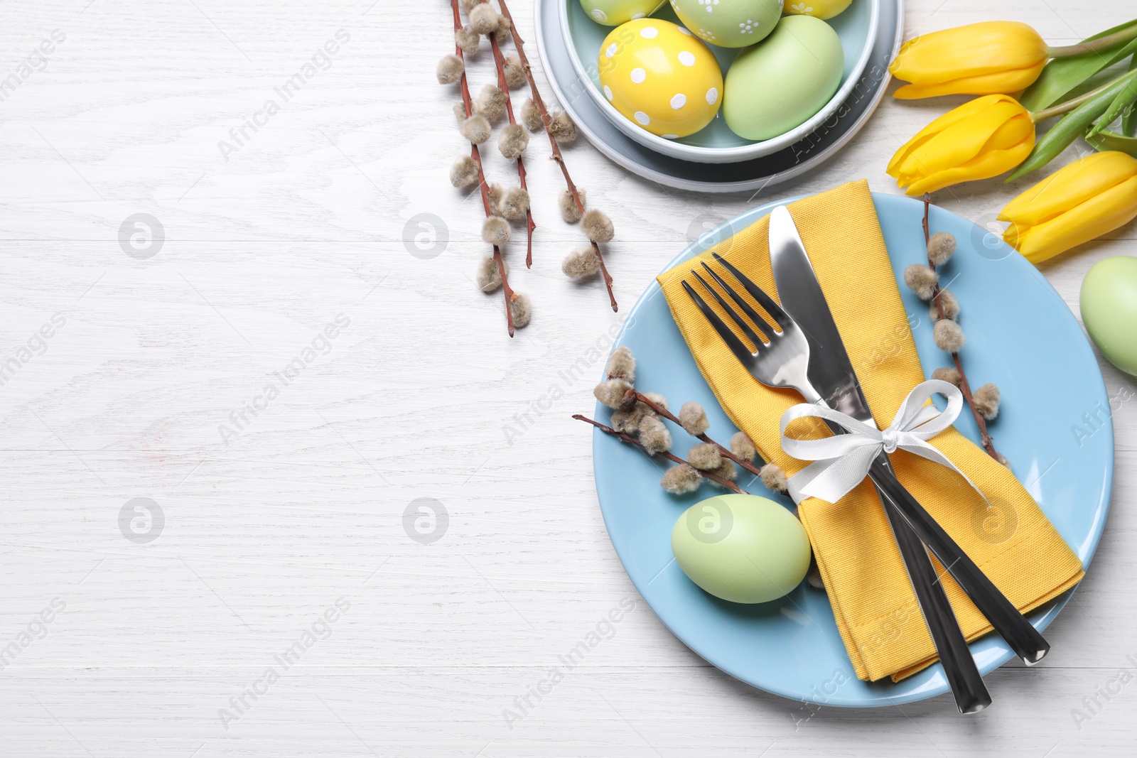 Photo of Festive Easter table setting with eggs on white wooden background, flat lay. Space for text