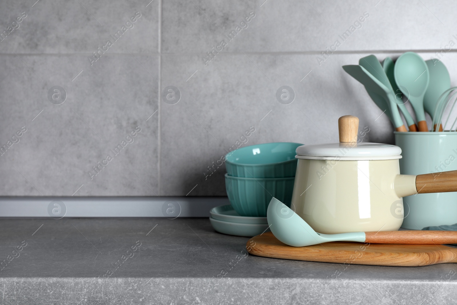 Photo of Set of different cooking utensils on grey countertop in kitchen. Space for text