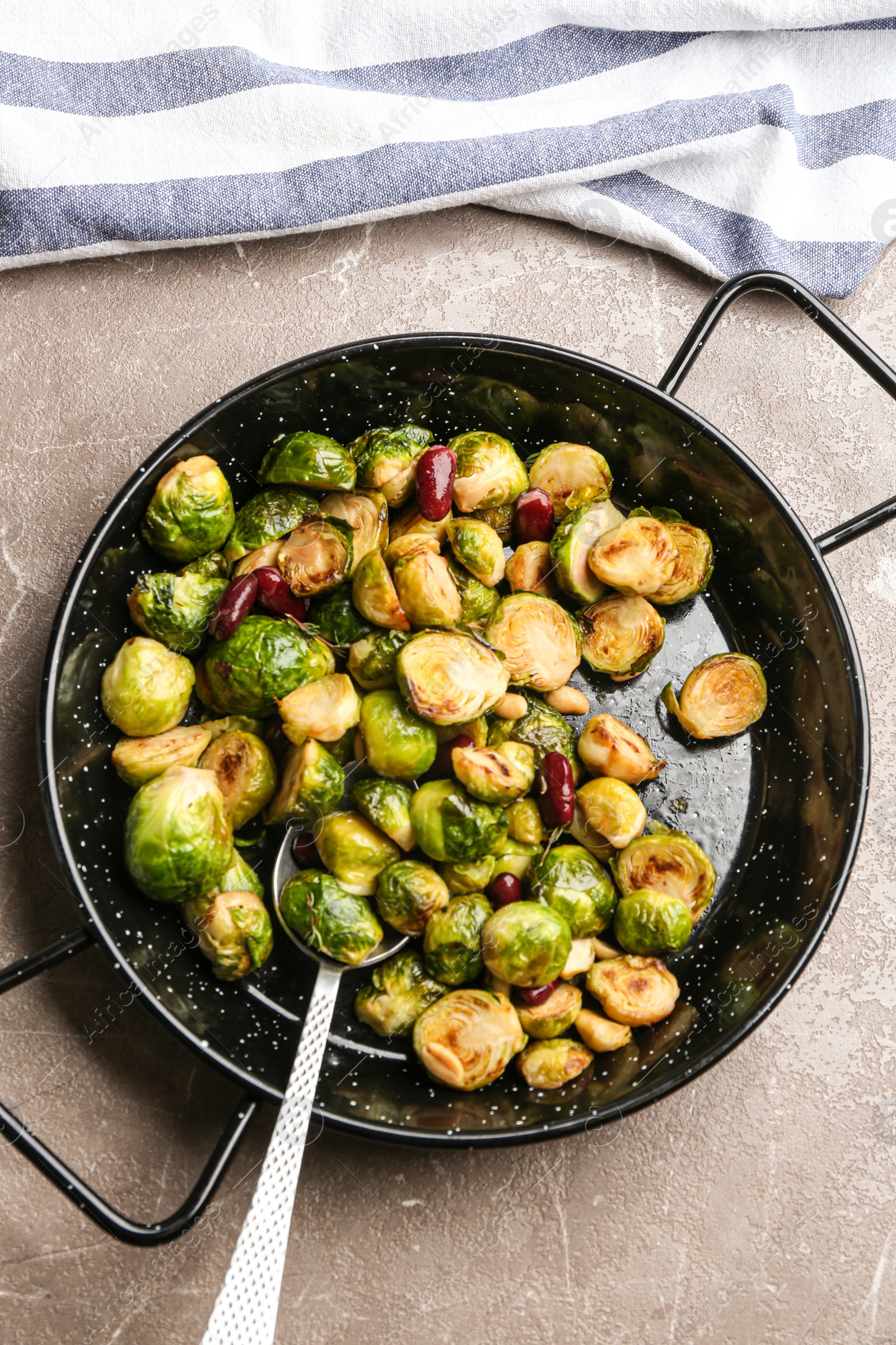 Photo of Delicious roasted brussels sprouts with red beans and peanuts on grey marble table, top view