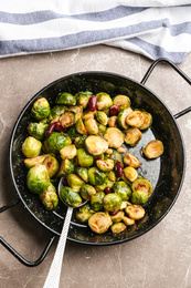 Delicious roasted brussels sprouts with red beans and peanuts on grey marble table, top view