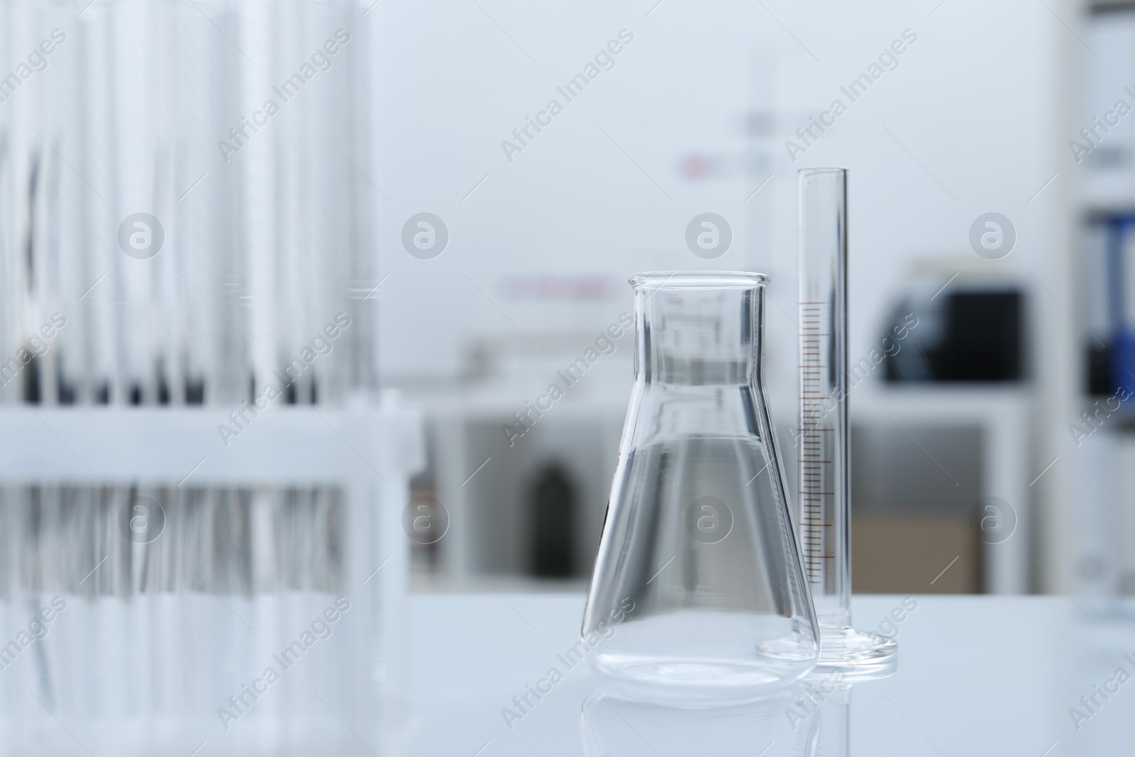 Photo of Laboratory analysis. Flask and test tubes on white table indoors