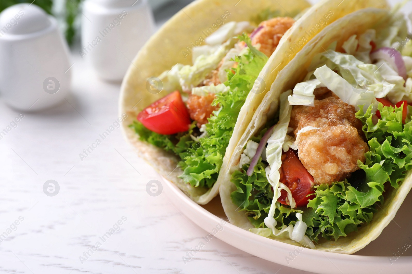 Photo of Yummy fish tacos served on white wooden table, closeup