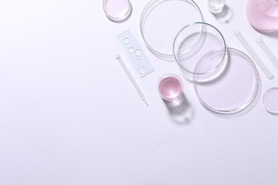 Organic cosmetic product and laboratory glassware on white background, top view. Space for text