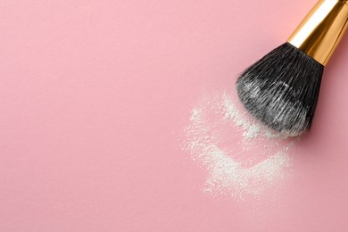 Photo of Makeup brush with rice loose face powder on pink background, top view. Space for text