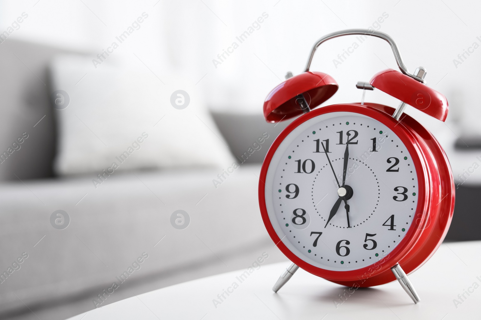 Photo of Alarm clock on table in living room. Time of day