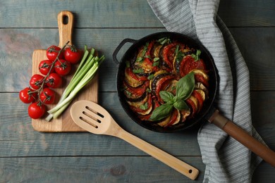 Delicious ratatouille and ingredients on light blue wooden table, flat lay