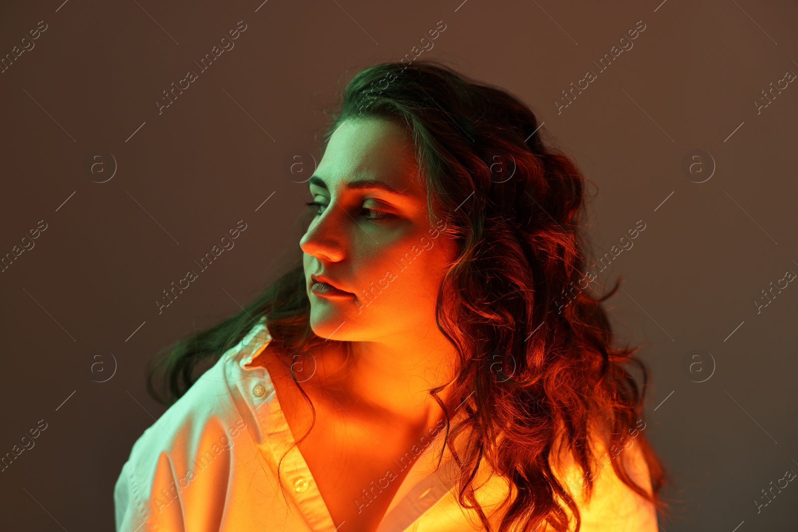 Photo of Portrait of beautiful young woman on color background with neon lights