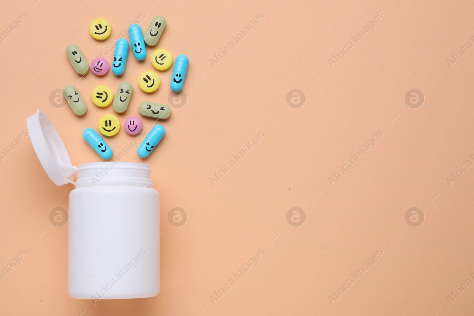 Photo of Bottle and antidepressant pills with funny faces on pale orange background, flat lay. Space for text