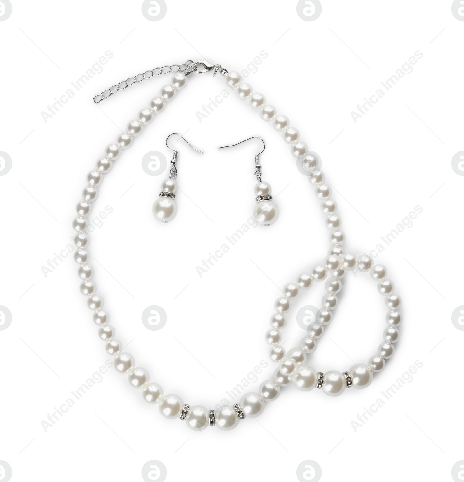 Photo of Elegant pearl necklace, bracelet and earrings on white background, top view