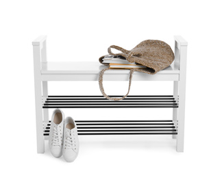 Stylish shoe shelf with sneakers and handbag isolated on white
